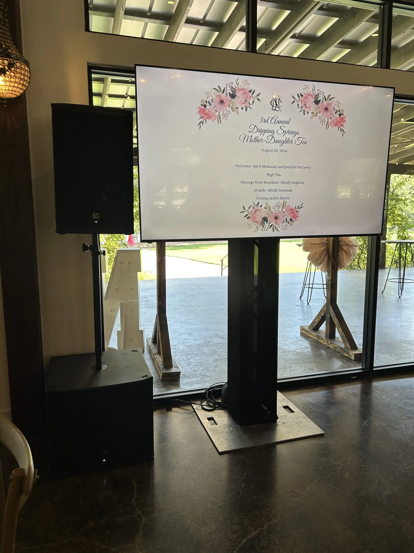 Display on a truss stand next to a column speaker at a corporate luncheon