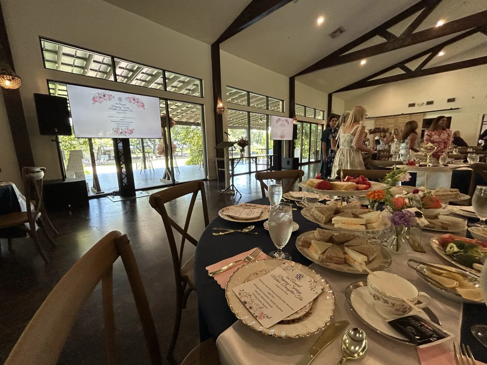 Wide view of an event room with a display visible from every table