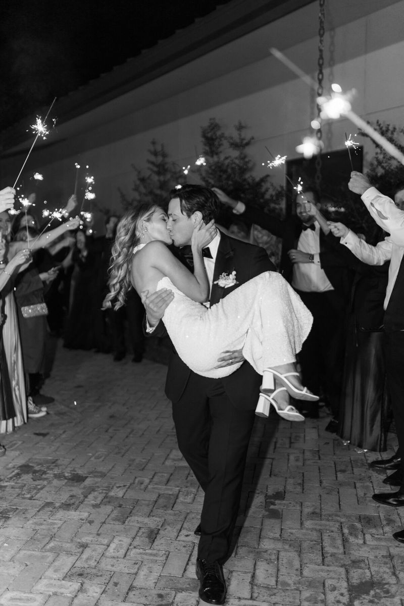 Black and white sparkler exit, groom carrying the bride