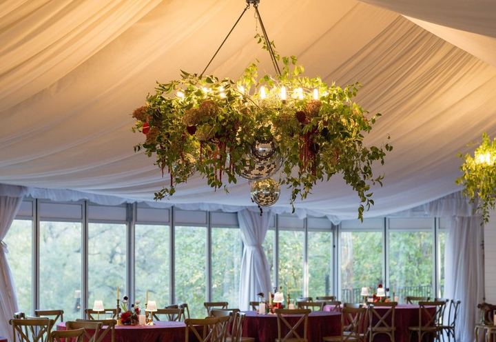 Tent reception under a hanging floral chandelier by Exquisite Petals