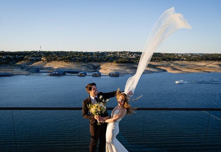 Couple above Lake Travis with the veil flying, by John Winters Photography