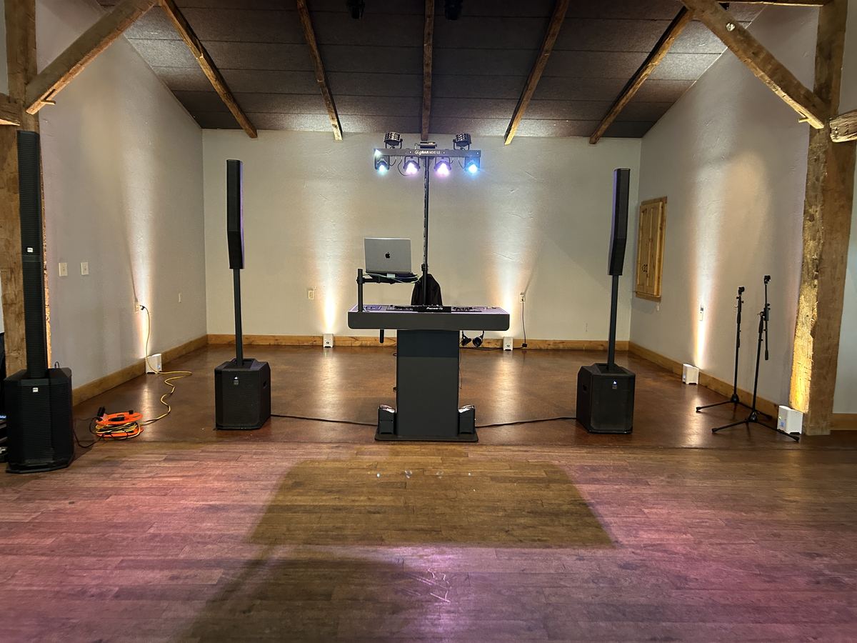 DJ booth and dance floor under the wood beams at Camp Lucy
