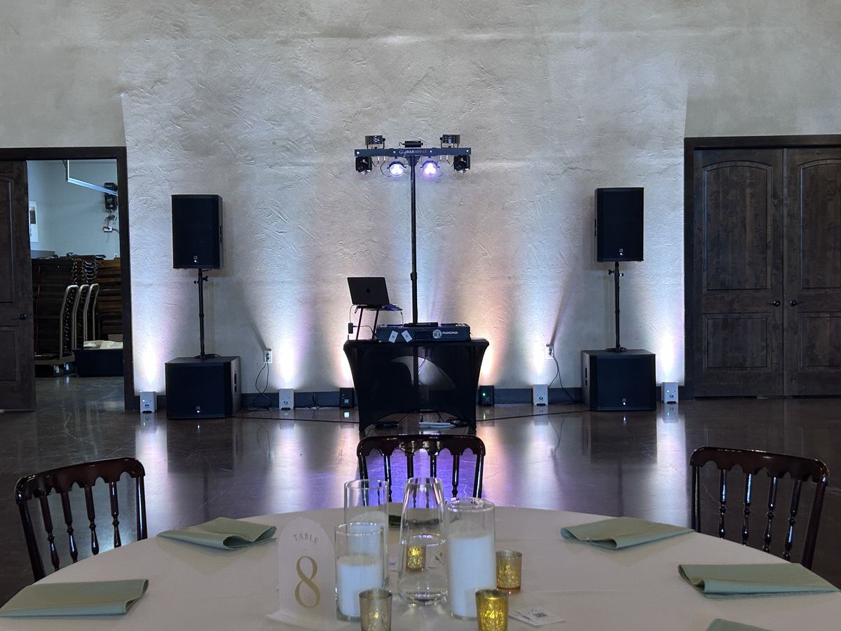 DJ setup with uplighting in the main hall at Ma Maison
