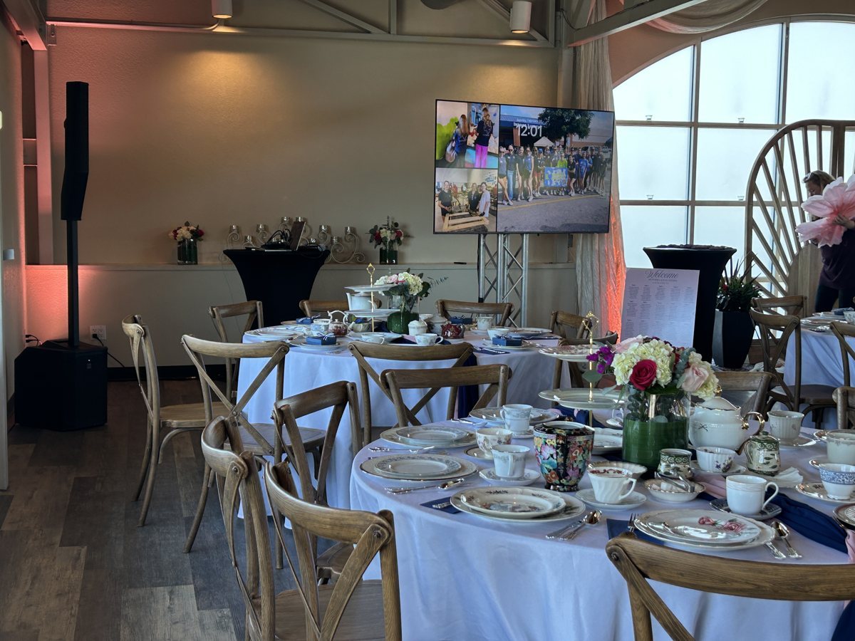 Our speakers and a screen on truss beside a set luncheon table