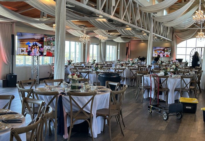 Luncheon tables under the draped ceiling at The Terrace Club, with screens on truss at the front