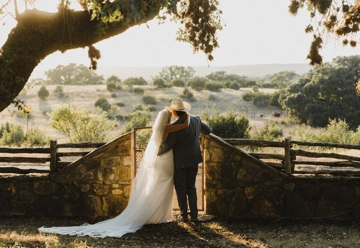 Couple at a ranch fence at sunset, from Wild at Heart Events
